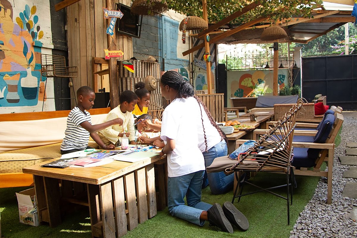 Animatrice BookSeed accompagnant quatre enfants pendant un atelier d'écriture